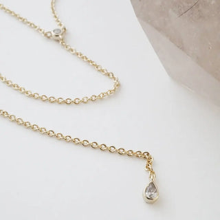 Delicate gold chain lariat necklace featuring round and teardrop crystals, perfect for versatile styling.