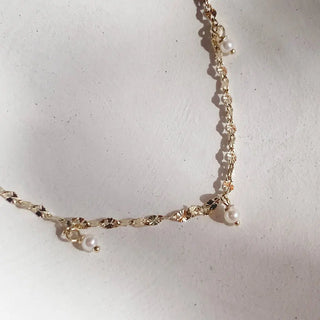 Margo Pearl Drop Necklace featuring a delicate gold chain with cultured freshwater pearls, adjustable length for versatile styling.