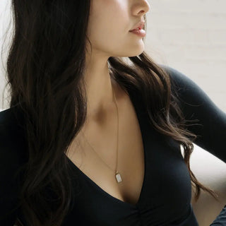 Model showcasing Moonlight Pendant Necklace with iridescent mother of pearl and engraved 'With Love' on the back.