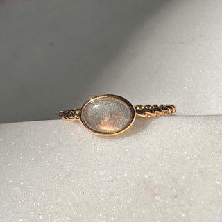 Dainty Nebula Labradorite ring with color-shifting stone on a twisted gold band, perfect for stacking or wearing solo.