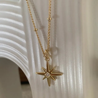 North Star Necklace featuring a celestial starburst charm with crystal, perfect for layering style. Adjustable length 20"-24".