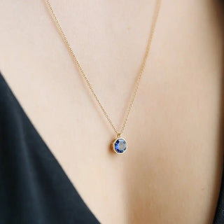 Ode to Rose Necklace featuring a radiant blue alexandrite crystal pendant on a delicate gold chain.