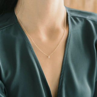 Petite solitaire necklace featuring a tiny bezeled crystal charm on a whisper thin chain, perfect for layering or wearing solo.