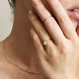 Elegant hand adorned with a gold ring and a Snail Chain Necklace, enhancing a chic and whimsical style.