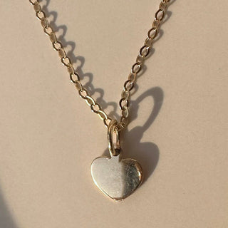 Solid 14k gold tiny heart charm on a delicate chain, perfect for personalized jewelry.