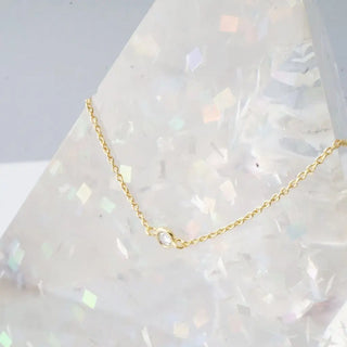 Solo Bezel Necklace featuring a tiny cubic zirconia crystal on a delicate gold chain, perfect for layering or wearing solo.