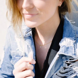 Model wearing the Wish Upon a Crystal Necklace with a clear wishing stone on a gold chain.