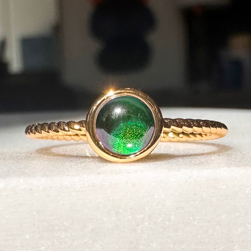 Dainty Baby Twist Mood Ring with color-shifting green stone on a twisted gold band, perfect for stacking or solo wear.